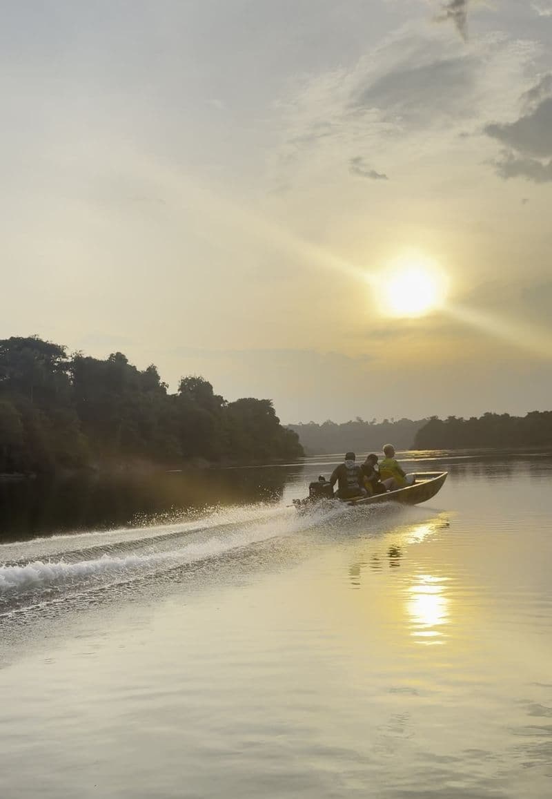 A boat crossing the river at sunset