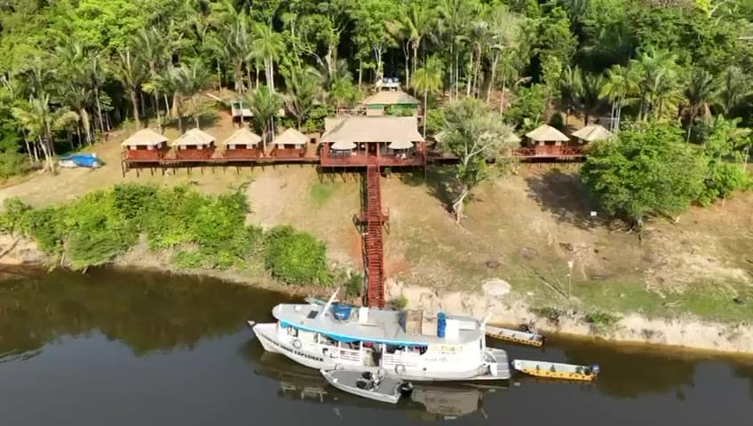 Camaiu Lodge on the river bank with a boat moored